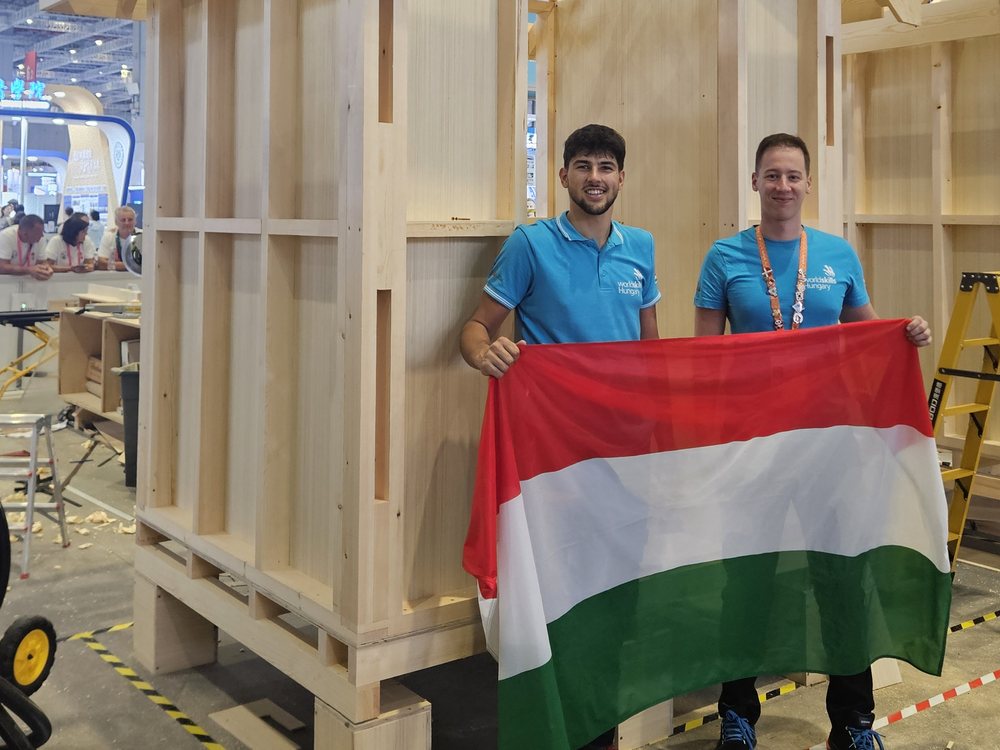 Zwei Teammitglieder vor dem fertiggestellten Holzhaus